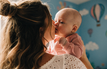 close up shot of mother kissing a baby