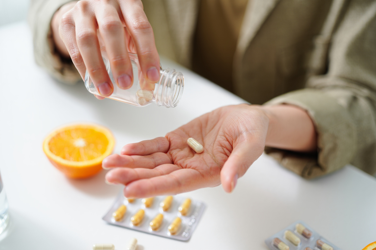 close up of person taking vitamin c supplement