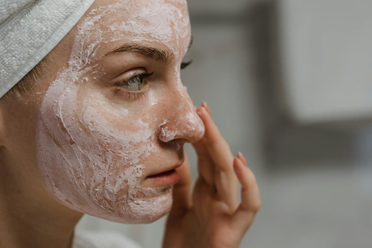 girl applying facial exfoliator