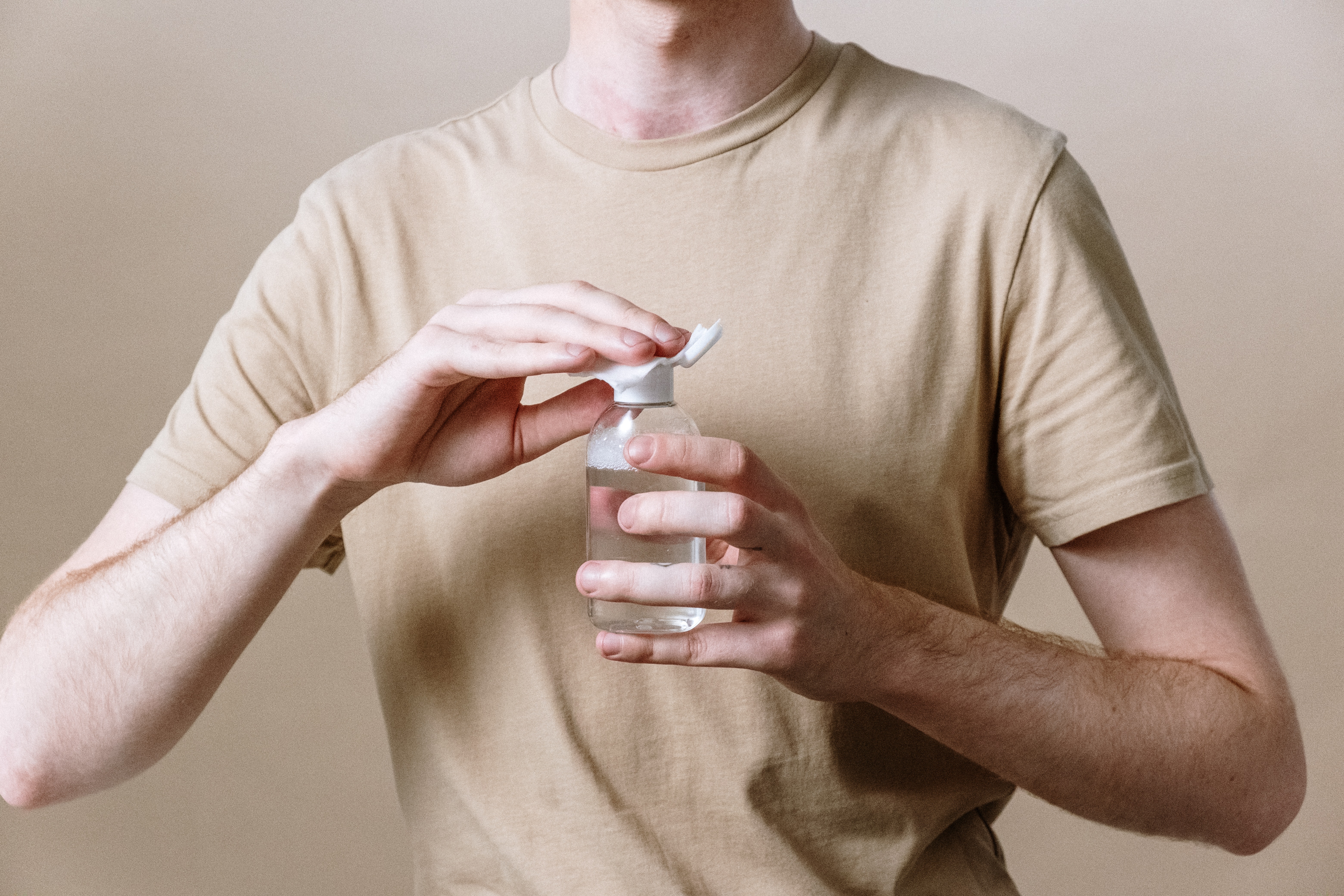 man applying micellar water to a cotton pad