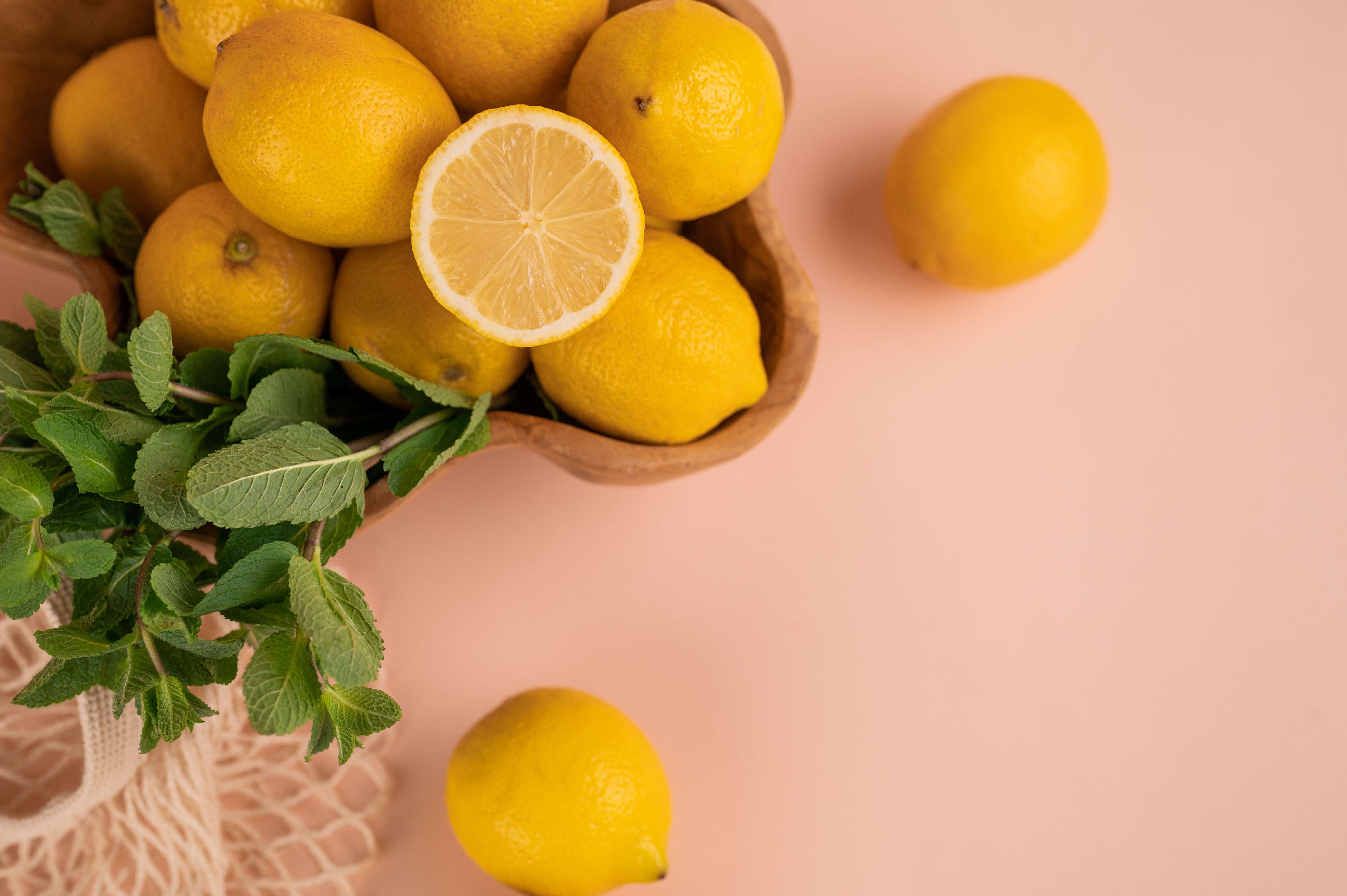 a pile of lemons on a pink background